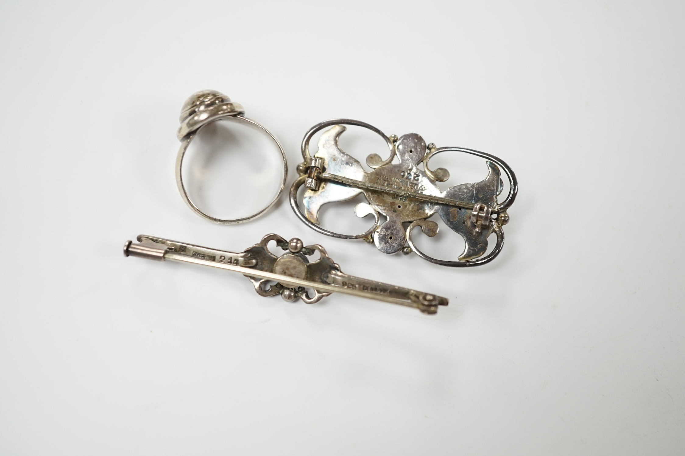 A Georg Jensen sterling and cabochon coral set bar brooch, design no. 214, 53mm, a similar Jensen brooch, design no. 236A, 37mm and a similar ring, design no. 46B, size M. Condition - fair to good